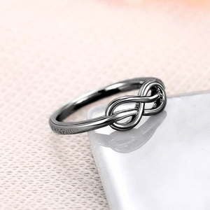 Macro-opname van zwarte infinity ring op wit keramiek met gedetailleerde metaaltextuur