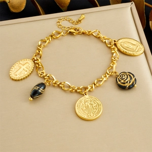 Detail of vintage gold bracelet with cross, black rose, and St. Benedict medal pendants
