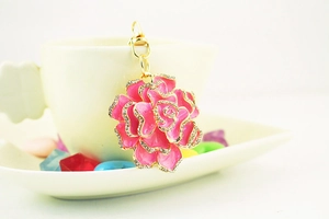 Close-up of pink flower keychain with rhinestones and a gold-tone lobster clasp
