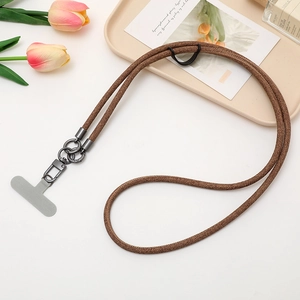 Detail of brown braided phone lanyard with dark grey metal clasp on elegant background