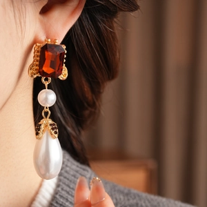 Detail view of vintage baroque gold earrings with deep red stone and teardrop pearl