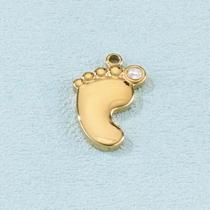 Detailed view of a gold baby footprint pendant with a small sparkling crystal inlay