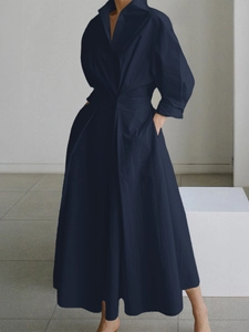 Détail d'une robe longue bleu marine à manches longues avec poches latérales et taille cintré