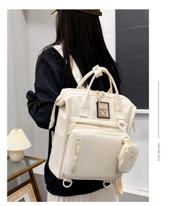 Detailed view of cream waterproof mummy backpack with cupcake coin purse accessory