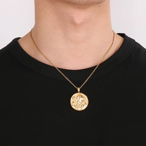 Pendentif médaille Saint Benoît en acier doré avec relief de croix porté par un mannequin
