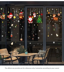 Close-up of Christmas window decals featuring Santa, reindeer, and snowflakes on glass