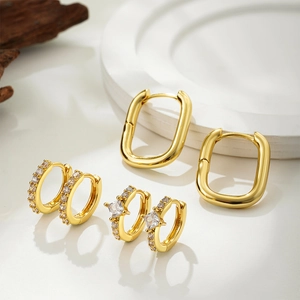 Detailed view of 18K gold earrings set with cubic zirconia on a minimalist tray