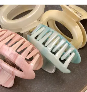 Close-up of assorted pastel acetate claw clips with elegant marble texture and spring