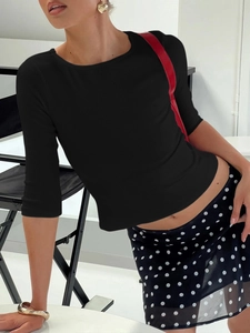Detail of black rib-knit top with half sleeves and a round neckline on a model