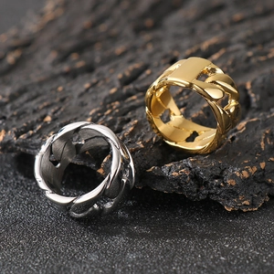 Cuban link style stainless steel rings in gold and silver finish on textured background