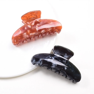 Elegant amber and blue marble pattern hair claws set on a ceramic plate display