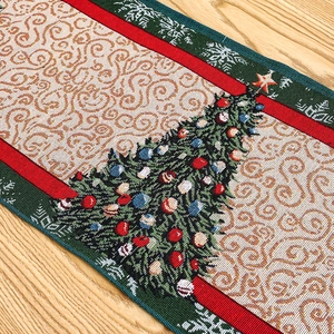Close-up of Christmas table runner with woven tree patterns and jacquard texture