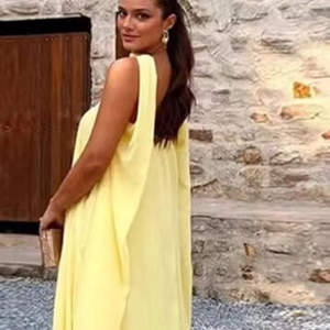 Robe longue jaune sans manches dos nu avec col foulard et coupe trapèze fluide au style élégant