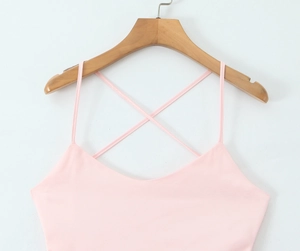 Detail of a pink camisole dress featuring elegant thin straps and a cross-back design