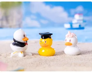 Detailed view of mini duck resin figurines featuring graduation and unicorn themes