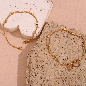 Detailed shot of double-layered gold snake chains with cubic beads and lobster clasp