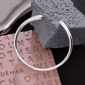 Minimalist silver Rupert teardrop open bangle with high-shine polished metallic finish