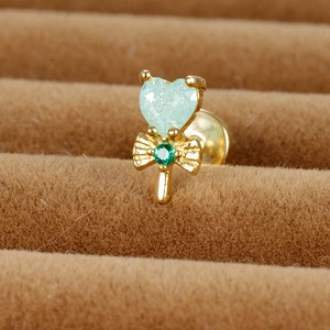 Détail d'une boucle d'oreille sucette cœur avec paillettes vertes et nœud doré