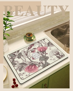 Absorbent kitchen drying mat with pink floral pattern on a marble countertop surface
