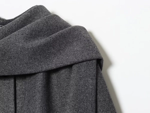 Detailed close-up of dark grey wool fabric showing fiber texture and heavy material