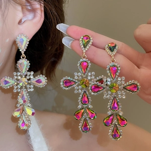 Macro shot of large cross earrings with colorful drop-shaped crystals and silver needle studs