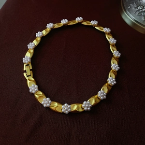 Detailed macro view of vintage gold flower bracelet with pearls and delicate craftsmanship