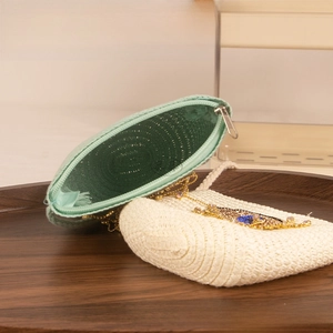 Detail of woven straw bags for kids with glitter eye patterns and metal zippers