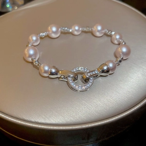 Gros plan d'un bracelet de perles avec fermoir en zircon sur socle doré champagne