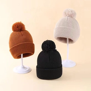 Set di tre berretti in maglia color caramello, nero e beige con soffici pompon per bimbi