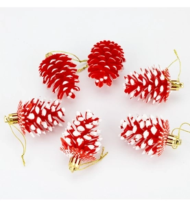 Détail de six pommes de pin rouges avec effet neige et cordons de suspension dorés