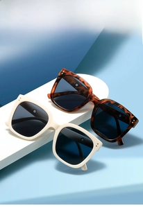 Detail of square oversized white and tortoiseshell sunglasses with metal rivets on frames