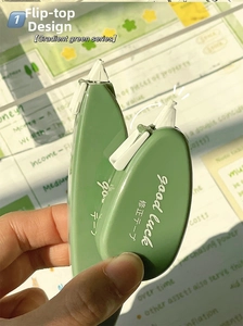 Dettaglio macro del nastro correttore verde sfumato con design a scatto su sfondo di un taccuino