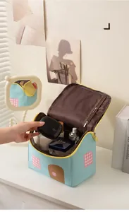 Dettaglio della grande borsa da toilette verde menta a forma di casa con scomparti in rete