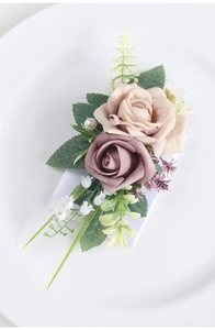 Detail of rose boutonniere featuring silk petals, green leaves and a white pearl accent