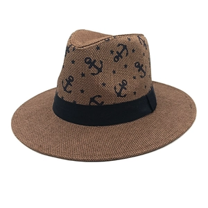 Detailed view of woven straw fedora featuring navy anchor prints and black ribbon trim