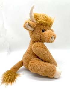 Detailed close-up of a brown plush Highland Cow with realistic long fur and curved horns