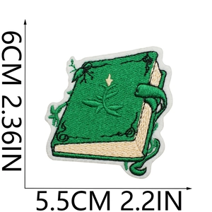 Detailed view of green magic book embroidery patch with dimensions showing 6cm x 5.5cm