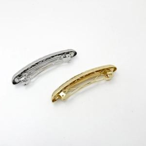 Close-up of gold and silver metallic pleated spring hair clips on white background