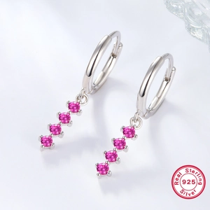 Detail of 925 sterling silver hoop earrings featuring four fuchsia pink gemstones