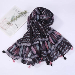 Detail of bohemian feather print scarf with bicolor tassels on a white background