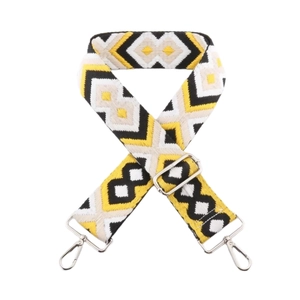 Detailed view of yellow geometric diamond embroidered strap with silver metal buckles
