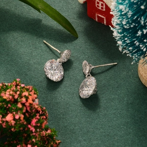 Macro detail of silver mesh weave earrings with clear zircon stones on festive background