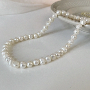 Detailed view of Baroque freshwater pearl necklace with natural textures on a ceramic plate
