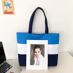 Detailed view of tri-color stitched canvas tote bag featuring blue and navy panels