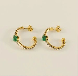 Detailed view of 18k gold plated C-shape earrings with emerald zirconia and fine accents