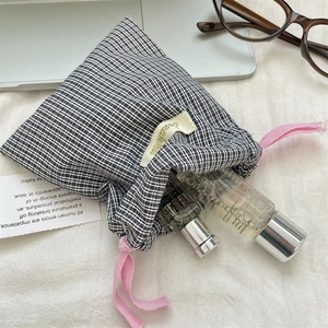 Portable black and white checkered drawstring bag with pink ribbon for makeup storage