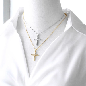 Detail of gold and silver cross necklaces with micro-pave zircons on a white mannequin