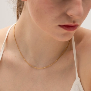 Elegant gold beaded snake chain necklace for women shown on a fashion model