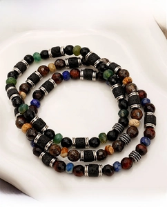 Detailed close-up of stacked multi-layered beaded bracelets with diverse natural gemstones