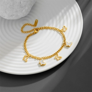 Gold stainless steel butterfly bracelet featuring white shell inlays and cut-out charms